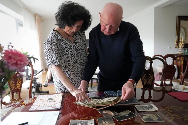 Holocaust survivor Herbert Rubinstein and his wife Ruth look at old photos after an interview with The Associated Press at their home in Duesseldorf, Germany, Thursday, April 25, 2024. Holocaust survivors from around the globe participating in a new digital campaign called "#CancelHate" which features videos of them reading Holocaust denial posts from different social media platforms. (AP Photo/Martin Meissner)