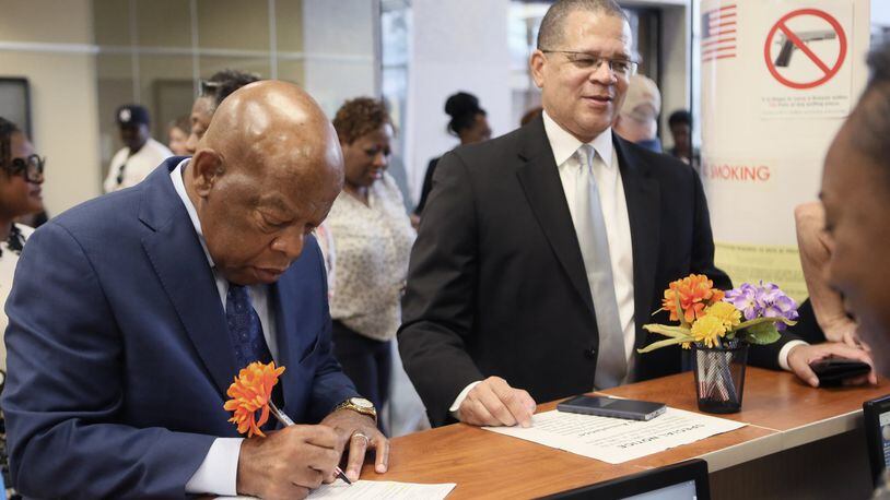 Congressman John Lewis (left) and Fulton County Chairman John Eaves sign in to vote. Eaves has embraced a role as convener of mayors, and will add another one if South Fulton voters create a new city. BOB ANDRES /BANDRES@AJC.COM AJC File Photo