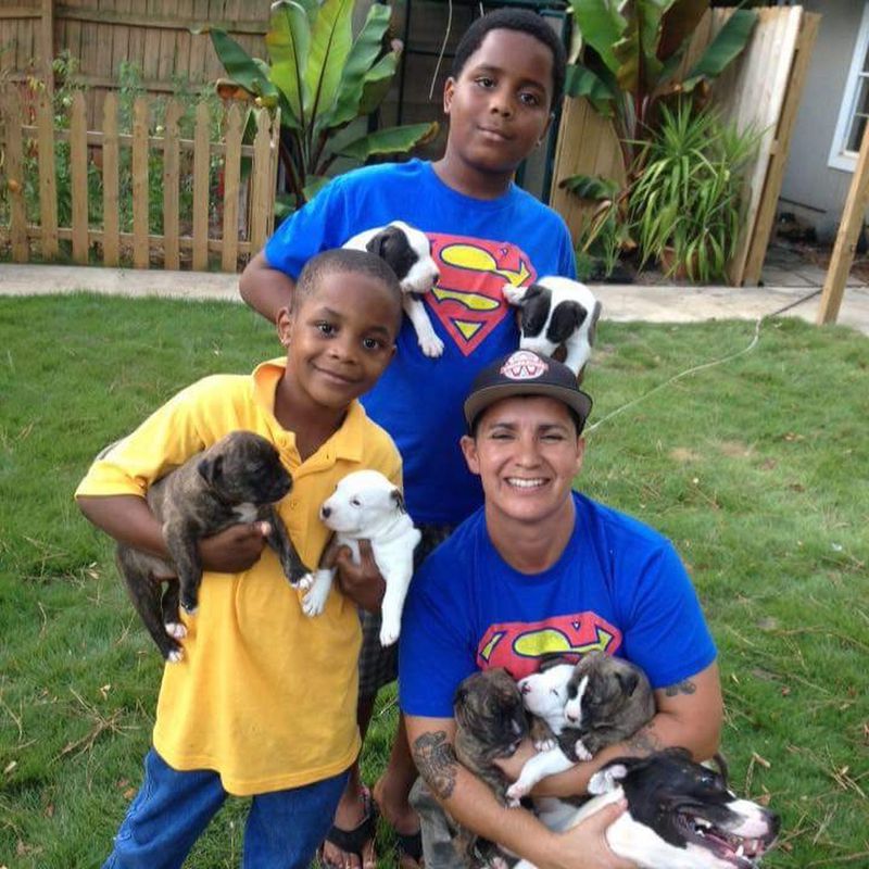 Grace Hamlin, founder of W-Underdogs, and two members of her crew show off puppies. CONTRIBUTED