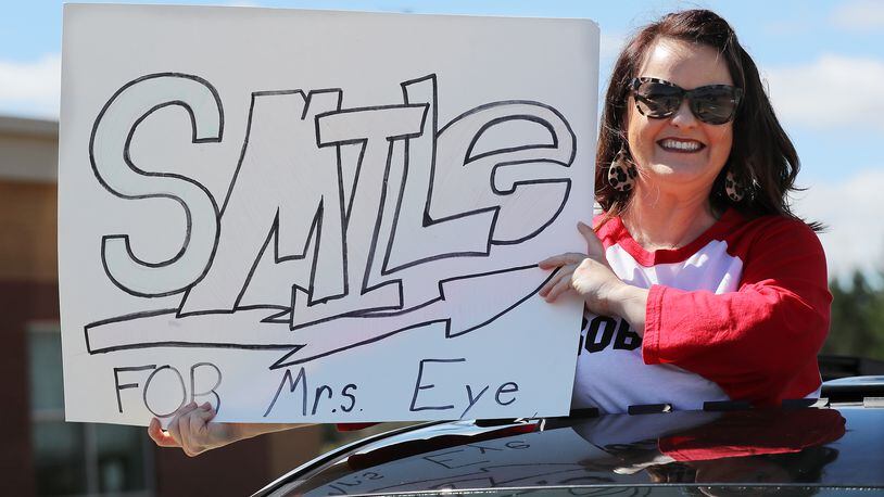 Gwinnett County third grade teacher Tracy Eye flashes her sign as teachers from Roberts Elementary hold an inspirational school parade driving through nearly two dozen Suwanee neighborhoods for some face-to-face contact -- while still maintaining social distance. Through the parade of cars on March 25, teachers were trying to ease the separation anxiety of their students during the coronavirus pandemic.
