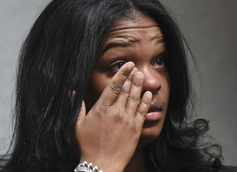 Ashley Smith wipes away tears as others talk about how she and others were mistreated recently at a Naperville, Ill. Buffalo Wild Wings restaurant.