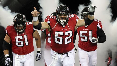 Todd McClure (62) leads the Falcons onto the field in 2012. CURTIS COMPTON / CCOMPTON@AJC.COM