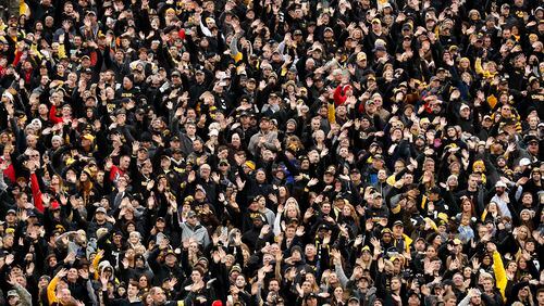 In this Nov. 4, 2017, photo, Iowa fans wave to children in the University of Iowa's children's hospital at the end of the first quarter of an NCAA college football game against Ohio State in Iowa City, Iowa. In the new tradition, known as The Wave, at the end of the first quarter fans in the 70,585-seat Kinnick Stadium turn to wave to the pediatric patients watching from the hospital, a 12-story building that overlooks the stadium from across the street. (AP Photo/Charlie Neibergall)