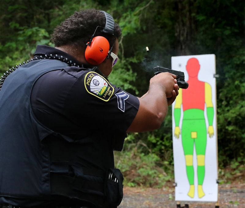 Senior officer Erik Vaugh fires his handgun during the training session. The yellow and green areas on the target represent the areas on the body that give the person shot a greater chance of survival. (Curtis Compton / Curtis.Compton@ajc.com)