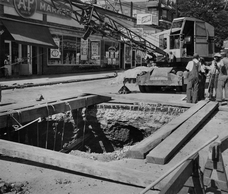 Original caption from August 1955: Workers move in to fill a huge chasm under Ponce de Leon Ave. The cavity at Penn Avenue extends 42 1/2 feet below the street and is 25 feet in diameter.