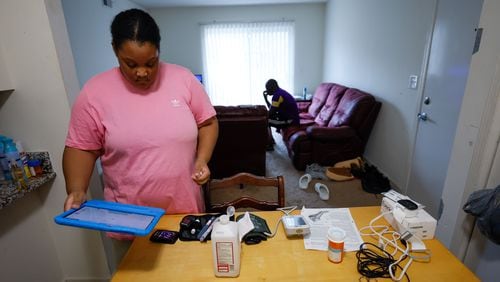 Asia Daniels, an Augusta University Medical Center patient, receives medical care without leaving the comfort of her home, through telemedicine. Here, she is preparing to take her vitals using equipment the hospital set up at her home, and she will send the results electronically to her nurses and doctors at the hospital. Tuesday, Nov. 21, 2023.  (PHOTO by Miguel Martinez / miguel.martinezjimenez@ajc.com)