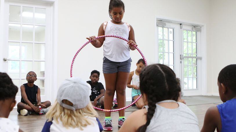 A camper presents her hula hoop to fellow campers during social emotional learning time at the ‘Water is Life’ collaborative youth enrichment camp at the Austell Youth Innovation Center in June. There is a new effort by schools and youth programs to help kids learn how to understand and manage emotions and form healthy relationships. (Christina Matacotta/christina.matacotta@ajc.com)