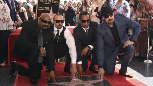 Sen Dog, from left, DJ Muggs, Eric "Bobo" Correa and B-Real, of hip-hop group Cypress Hill, atop their new Hollywood Walk of Fame star on April 18, 2019. CHRIS PIZZELLO/INVISION/AP