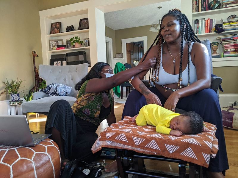 Midwife Kiki Jordan examines TaNefer Camara during a routine postnatal visit about a week after the birth of her son, Esangu. In centuries past, Black midwives often functioned as spiritual advisers and parenting teachers as well as birth attendants. (Photo by Rachel Scheier/California Healthline/TNS)