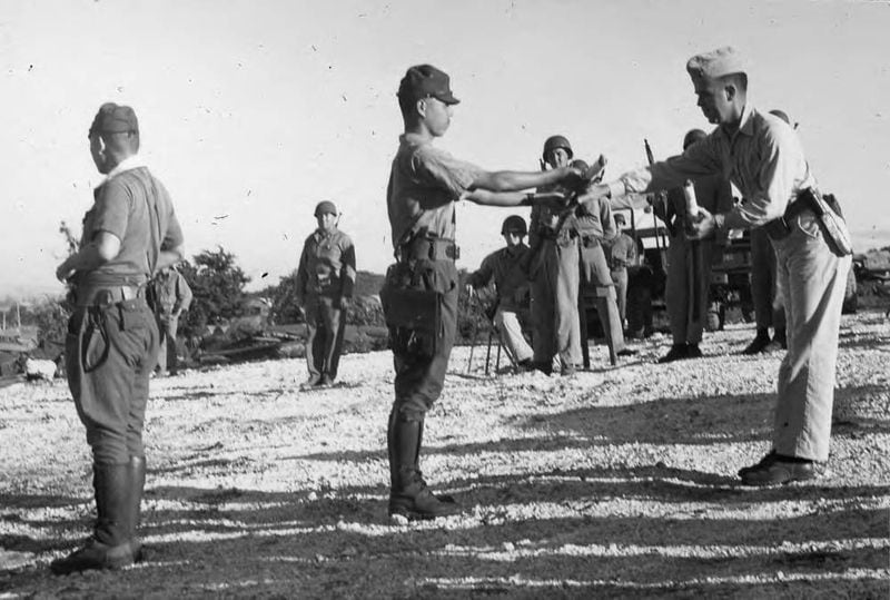 Japanese Capt. Sakae Ōba hands over his sword to Lt. Colonel Howard G. Kurgis, USMC, at Saipan on Dec. 1, 1945, three months after the war was over.