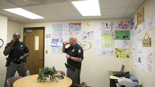 Officers Tomario Rowe (left) and Robert Lemke, of the Johns Creek Police Department, enjoy a snack in the “Bear Den” at Barnwell Elementary School on Thursday, Sept. 20, 2018. They are two of the three police officers who cover Barnwell Elementary as part of their regular on-duty rotation. The idea behind the Bear Den, a room in the school for officers to relax, do paperwork and grab refreshments, is to increase police presence at the school and deter potential threats. CASEY SYKES / CASEY.SYKES@AJC.COM