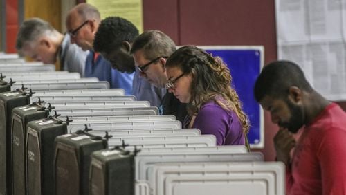 Voters pondered the ballots at Henry W. Grady High School in Atlanta on Tuesday May 22, 2018. JOHN SPINK/JSPINK@AJC.COM