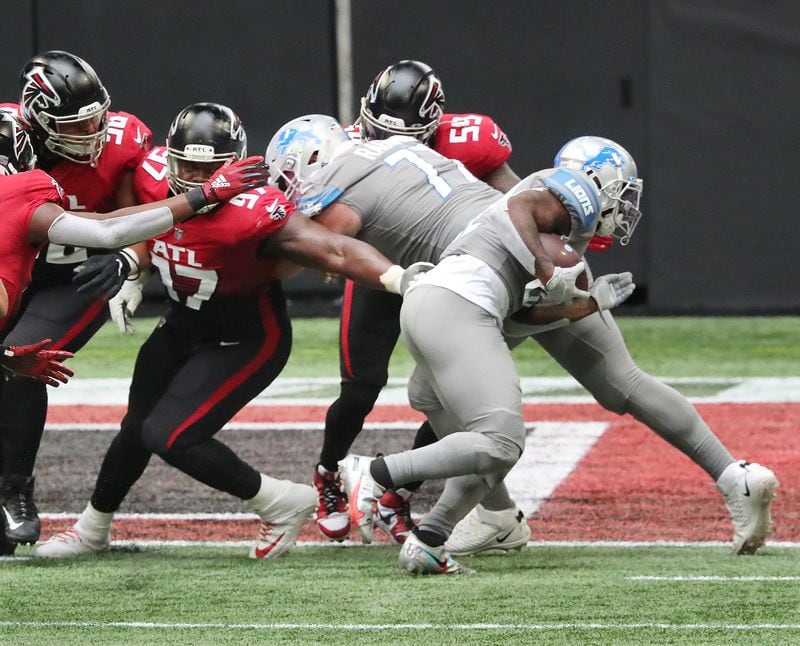 Lions running back D’Andre Swift (right) slips away from the grasp of Falcons defender Grady Jarrett for a touchdown in the first quarter Sunday, Oct. 25, 2020, at Mercedes-Benz Stadium in Atlanta. (Curtis Compton / Curtis.Compton@ajc.com)