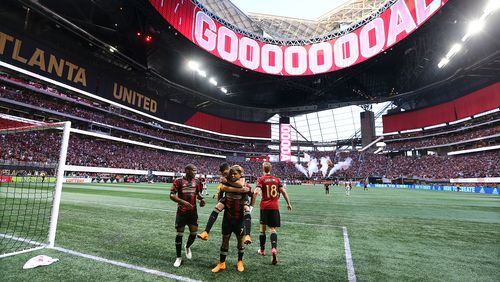 Atlanta United forward Josef Martinez celebrates his goal on a penalty kick with teammates while Miguel Almiron jumps on his back for a 1-0 lead against Philadelphia Union during the first half in a MLS soccer match on Saturday, June 2, 2018, in Atlanta.  Curtis Compton/ccompton@ajc.com