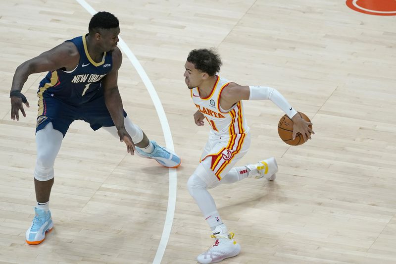 Atlanta Hawks guard Trae Young (11) works against New Orleans Pelicans forward Zion Williamson (1) in the first half of an NBA basketball game Tuesday, April 6, 2021, in Atlanta. (AP Photo/John Bazemore)
