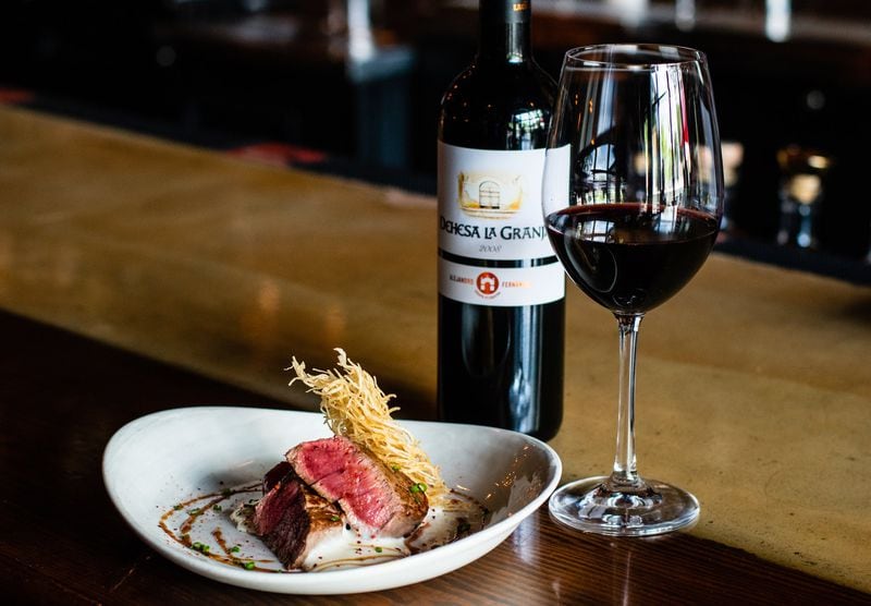 Solomillo, or seared beef tenderloin, with a glass of Tempranillo at the Iberian Pig. CONTRIBUTED BY HENRI HOLLIS