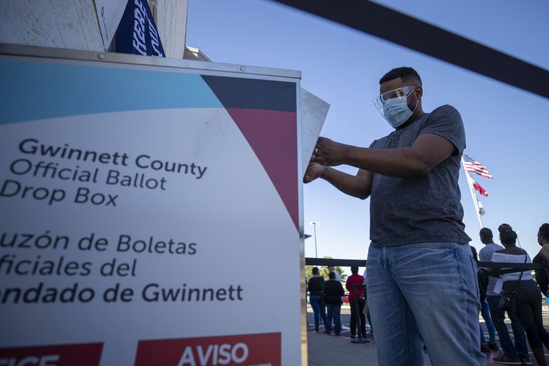 A resident of Gwinnett County, Ga. Places their mail-in ballot in an official drop box on the second day of early voting at the Gwinnett County Voter Registration and Election Building in Lawrenceville on October 13, 2020. (Alyssa Pointer / Atlanta Journal- Constitution / TNS)