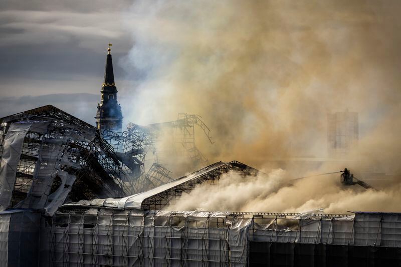 Firefighters work as smoke rises out of the Old Stock Exchange in Copenhagen, Denmark, Tuesday, April 16, 2024. A fire raged through one of Copenhagen’s oldest buildings on Tuesday, causing the collapse of the iconic spire of the 17th-century Old Stock Exchange as passersby rushed to help emergency services save priceless paintings and other valuables. (Emil Helms/Ritzau Scanpix via AP)
