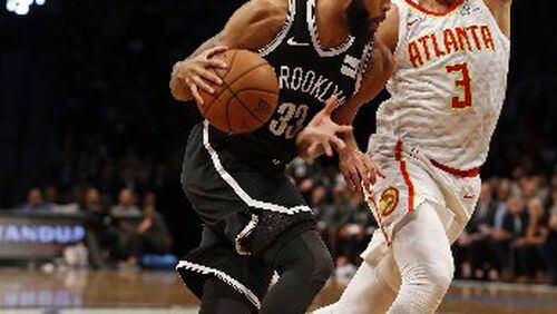 Allen Crabbe got the best of the Hawks early but Marco Belinelli answered late. (AP Photo)