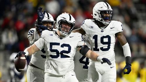 Penn State defensive tackle Jordan van den Berg (52) celebrates with defensive end Jameial Lyons (19) and defensive tackle Coziah Izzard (99) after recovering a fumble by Maryland during the second half of an NCAA college football game, Saturday, Nov. 4, 2023, in College Park, Md. (AP Photo/Nick Wass)