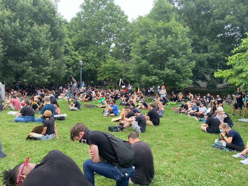 Protesters sit in silence for eight minutes and 46 seconds in Freedom Park on Saturday, June 6, 2020, to honor the life of George Floyd. A Minneapolis police officer had his knee on Floyd’s neck for eight minutes and 46 seconds before Floyd died. (Photo: Sarah Kallis / AJC)
