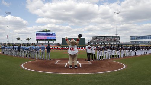 Tampa Bay Rays (left) and Atlanta Braves players line the baselines after the national anthem and ceremony to open the Braves' new spring training home, CoolToday Park, Sunday, March 24, 2019, in North Port, Fla.