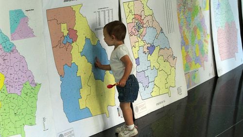 A child looks over redistricting maps during a 2011 public hearing.