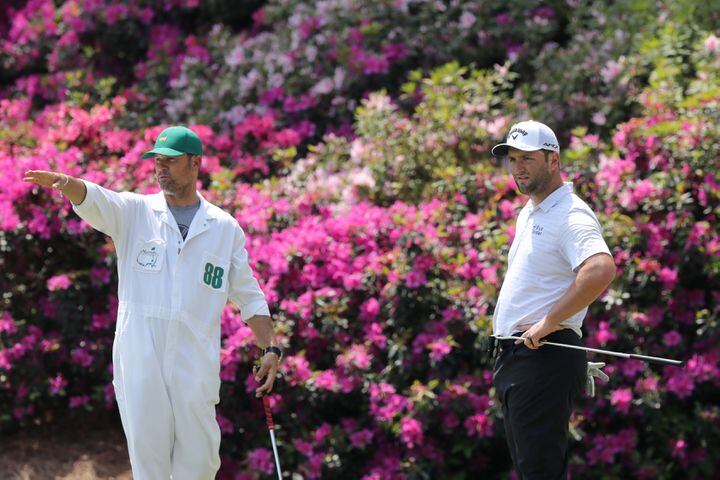 April 7, 2021, Augusta: Jon Rahm, right, prepares to putt on the thirteenth hole next to his caddy Adam Hayes during his practice round for the Masters at Augusta National Golf Club on Wednesday, April 7, 2021, in Augusta. Curtis Compton/ccompton@ajc.com