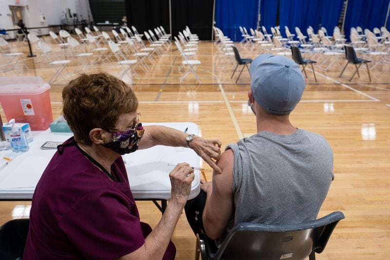 Registered Nurse Judy Spaulding gives Cody Luke his first COVID-19 vaccine shot on the last operating day of the mass vaccination site at the University of North Georgia's Gainesville campus on July 30. (Ben Gray for the Atlanta Journal-Constitution)