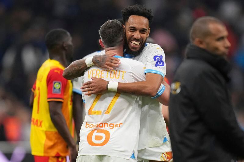 Marseille's Pierre-Emerick Aubameyang, centre right, hugs Marseille's Jordan Veretout after defeating Lens in a French League One soccer match between Marseille and Lens at the Stade Velodrome stadium in Marseille, France, Sunday, April 28, 2024. Marseille won 2-1. (AP Photo/Daniel Cole)