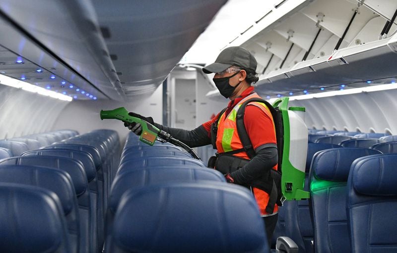 Juan Zenozain sanitizes aircraft cabin using an electrostatic sprayer on Concourse A  at Hartsfield-Jackson International Airport in Alanta on Wednesday, July 22, 2020. (Hyosub Shin / Hyosub.Shin@ajc.com)