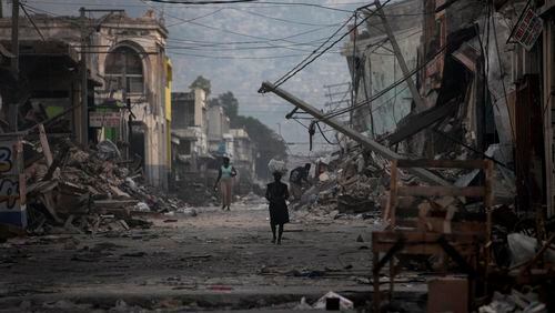 A woman walks down a devastated street in Port-au-Prince, Haiti, in the wake of a 2010 earthquake. (AP)