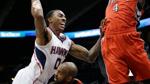 Atlanta Hawks guard Jeff Teague (0) drives against Toronto Raptors' Quincy Acy (4) and John Lucas (5) during the first half of an NBA basketball game Wednesday, Jan. 30, 2013, in Atlanta. Teague was called for an offensive foul. (AP Photo/John Bazemore)