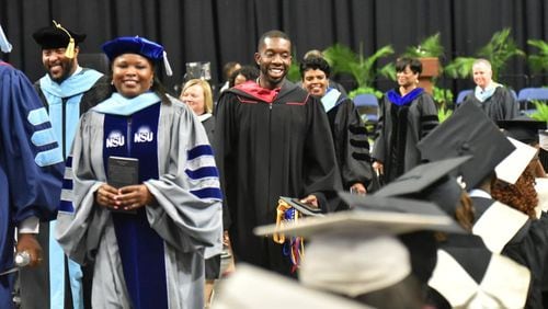 Everton Blair (center), district 4 member of the Gwinnett County Board of Education, with other school officials smiles as he leaves after the Shiloh High School graduation ceremony at Gwinnett Infinite Energy Center on Wednesday, May 22, 2019. Everton Blair, the first black and youngest member of the Gwinnett County Board of Education is also a graduate of Shiloh High School. At the graduation ceremony, he commemorated his 10 anniversary from the school by paying off any outstanding fines or fees that are keeping any of the graduates from receiving their diplomas. He also gave out three scholarships. "I may not be a billionaire," he said referencing Robert F. Smith's recent gift to Morehouse grads, "But every little bit helps." HYOSUB SHIN / HSHIN@AJC.COM