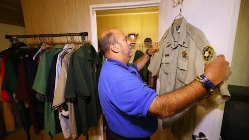 Hanging it up after 31 years, Putnam County Deputy Sgt. John Harper gathers the police uniforms from the closet of his home preparing to turn them in at week's end on Wednesday, Nov. 17, 2021, in Hillsboro. Harper had a sudden epiphany recently that it was time to go, in part because of the current climate involving law enforcement. Once he made his decision, he was ready to go immediately. (Curtis Compton / Curtis.Compton@ajc.com)
