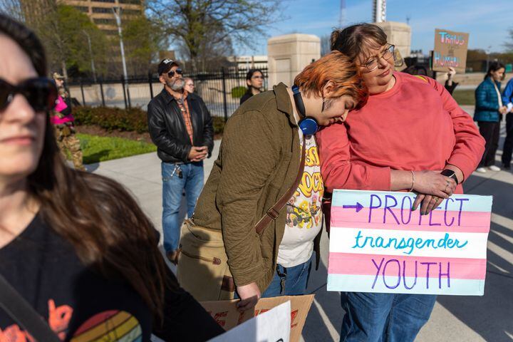 Andy Welch (center) and Andy’s mother Tina Welch lean on each other at a rally against SB 140 outside the Capitol in Atlanta on Monday, March 20, 2023. SB 140 would prevent medical professionals from giving transgender children certain hormones or surgical treatment. (Arvin Temkar / arvin.temkar@ajc.com)