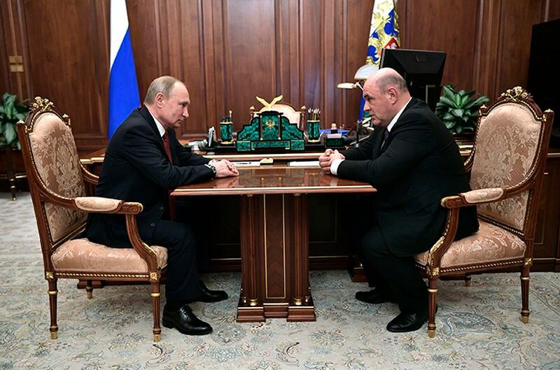 Russian President Vladimir Putin, left, listens to Tax Service chief Mikhail Mishustin Wednesday during their meeting in the Kremlin in Moscow.
