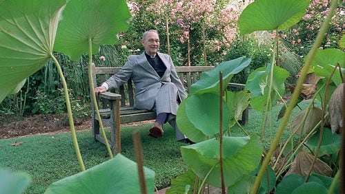 Father Austin Ford, sits outside surrounded by Lotus garden with his Roses located in the background of his Emmaus House. (Eric Williams / AJC File)