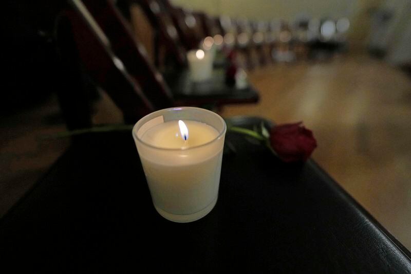Thirteen chairs are empty with candles and roses to remember 25th anniversary of the Columbine High School mass shooting, Friday, April 19, 2024, in Denver. (AP Photo/Jack Dempsey)