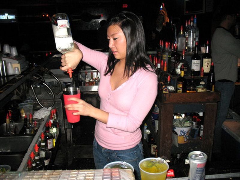Mimi Han, who pours a sweet and savory Blue Bombshell shot, tends one of four bars at Hole in the Wall nighclub, which has been a Buckhead fixture for 12 years.