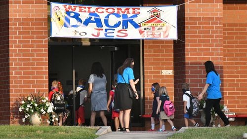 July 31, 2020 Jefferson - Jefferson Elementary School staff greet students for their first day back to school in Jefferson on Friday, July 31, 2020. More than 1,500 students and 100-plus staff and faculty in Jefferson are scheduled to resume classes in-person beginning this Friday. The schoolÕs first day is one of the earliest returns to school in the U.S., following the months of quarantine and school modifications due to COVID-19. (Hyosub Shin / Hyosub.Shin@ajc.com)