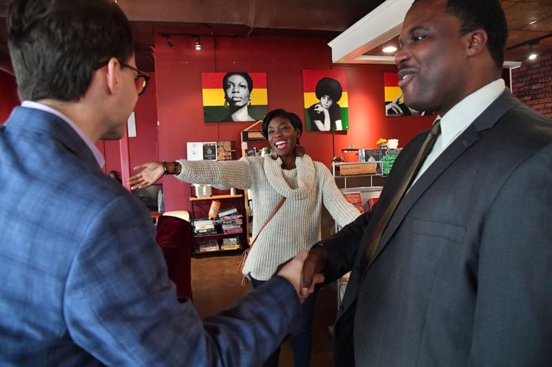 Janelle Jones greets Tony Gonzalez (left) and Greg Clay before their meeting at Urban Grind coffeehouse in Atlanta on Tuesday, December 20, 2016. HYOSUB SHIN / HSHIN@AJC.COM