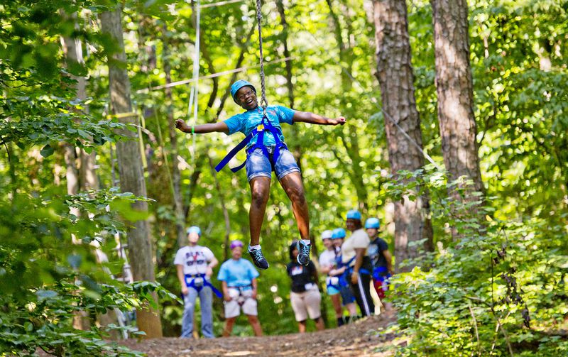 Noa Bennafield flies through the air on a zip line at Camp Timber Ridge in Mableton. The Girl Scout camp is one of 48 in Georgia accredited by the American Camp Association. JONATHAN PHILLIPS / SPECIAL