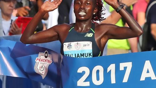 Aliphine Tuliamuk hits the finish line to win the women’s division in the 48th running of the AJC Peachtree Road Race with an unofficial time of 32:49 on Tuesday, July 4, 2017, in Atlanta. Curtis Compton/ccompton@ajc.com