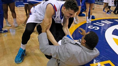 Georgia State head coach Ron Hunter, bottom, is helped up by his son, Georgia State guard R.J. Hunter, after they defeated Georgia Southern in the NCAA college basketball championship of the Sunbelt Conference tournament in New Orleans, Sunday, March 15, 2015. Georgia State defeated Georgia Southern 38-36. (AP Photo/Bill Haber) The Hunters of Georgia State: Down but dancing. (Bill Haber/AP photo)