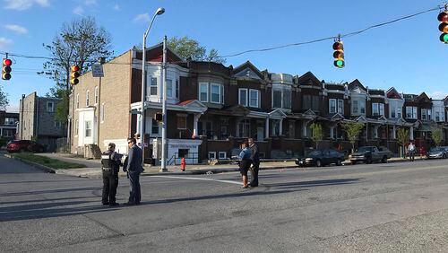 Authorities stand at Edmondson and Whitmore after multiple people were shot, Sunday, April 28, 2019, in west Baltimore. At least one person was killed and six others wounded.
