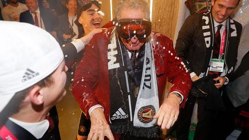 No one is safe: Atlanta United owner Arthur Blank is doused by Miguel Almiron during the MLS Cup celebration.