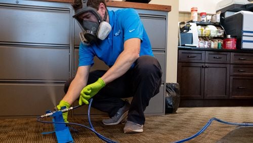 Joshua Bellows, owner of Pure Maintenance of Georgia, sets up a sanitizing and anti-microbial “dry fog” system at an office in Alpharetta on Tuesday evening May 12, 2020. Bellows first uses an acetic acid and hydrogen peroxide mist to sanitize the office, then an anti-microbial mist that he says attracts viruses with its electrical charge, then destroys the virus for up to 90 days. Ben Gray for The Atlanta Journal-Constitution