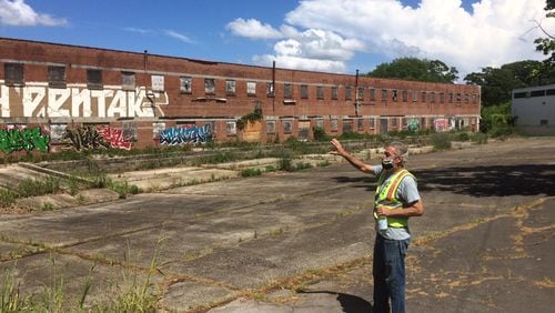 Southwest Atlanta resident Matt Garbett points out an old canning factory in the abandoned 20-acre parcel of old brick industrial buildings called Murphy Crossing. (Photo by Bill Torpy)
