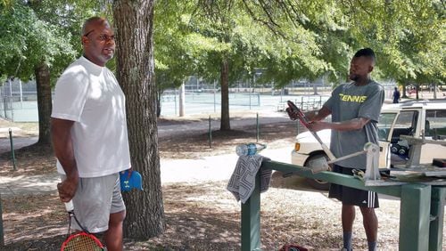 Darrell Hooker (left), prepares for a tennis lesson with Scott Ross at Trammell Crow Park. “I want to know how they are going to enforce it” Ross said of the smoking ban. BOB ANDRES /BANDRES@AJC.COM